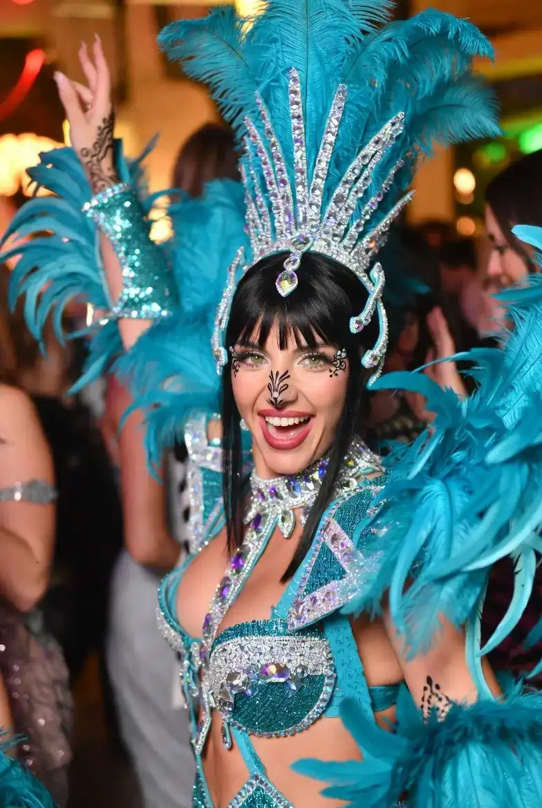 שירה במופע סמבה ברזילאי עם נוצות צבעוניות בחינה